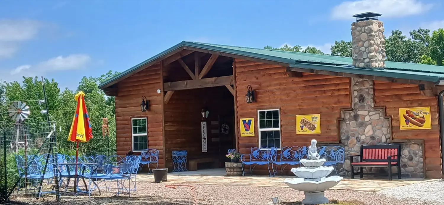 The log building, green roof and stone chimney of Medicine Bow Farms.
